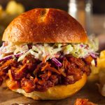 Photo of a BBQ jackfruit slider piled high with coleslaw
